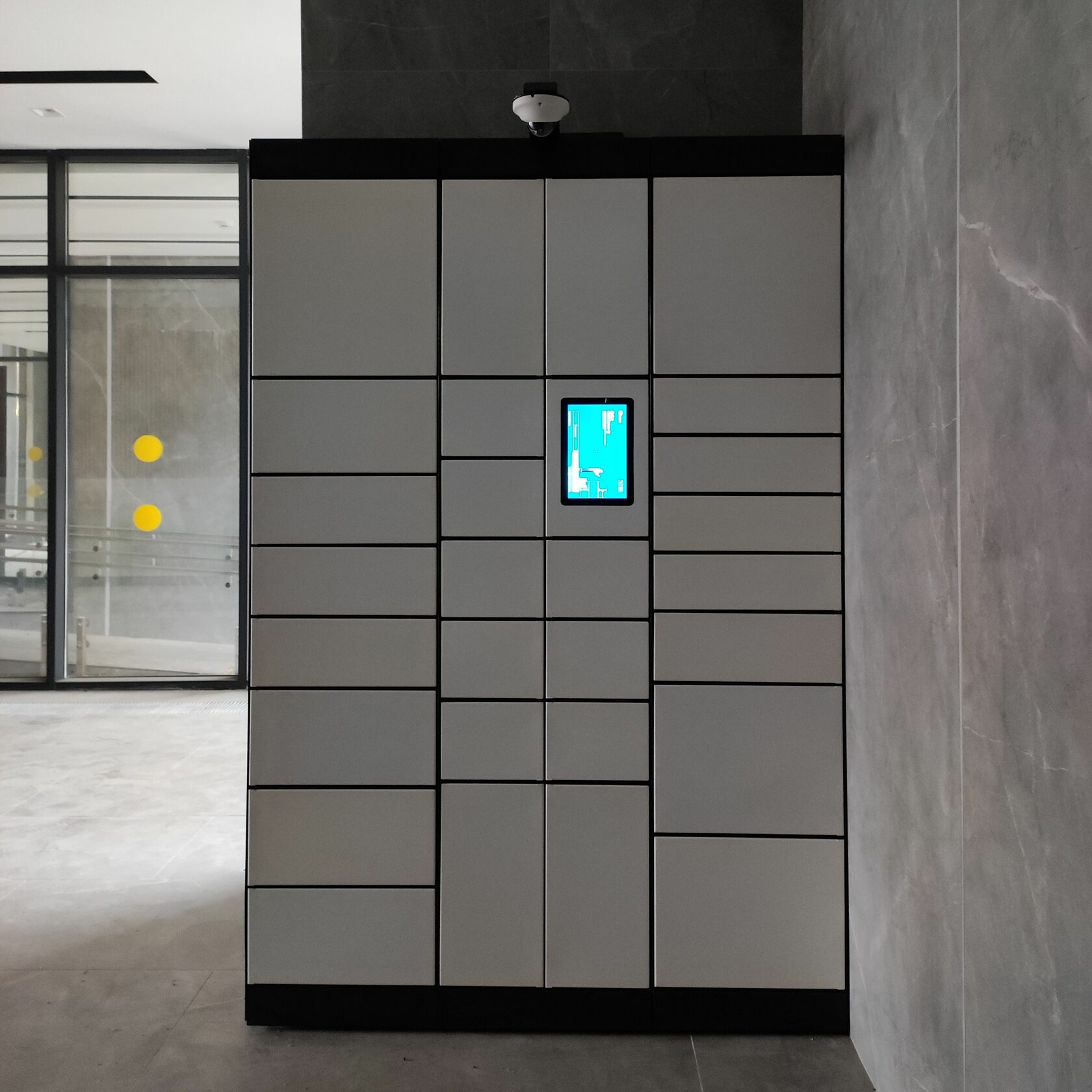 Установленный постамат IZIBOX рядом со стеклянной перегородкой